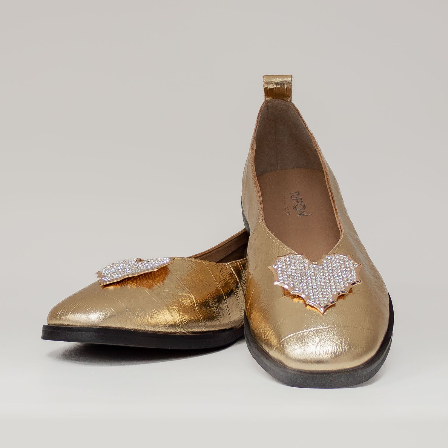 Skórzane baleriny Tuffoni w kolorze złotym, z aplikacją z cyrkonii w formie serca, pokazane od przodu.