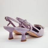 Odsłonięta pięta i subtelny pasek z klamerką w liliowych czółenkach Alma En Pena – widok z tyłu.