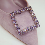 Zbliżenie na klamrę z fioletowych kryształków na czubku czółenka z naturalnego zamszu marki Alma En Pena.