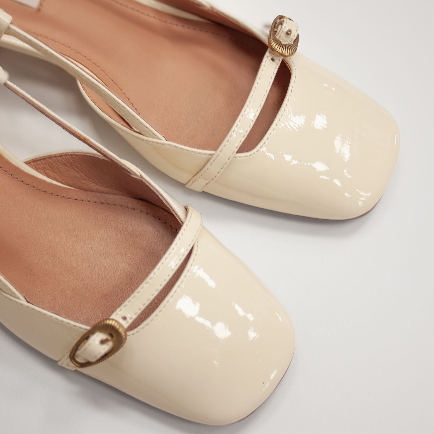 Hiszpańskie czółenka z odkrytą piętą Bibi Lou – kremowe, skórzane, lakierowane, zbliżenie na fakturę naturalnej skóry.