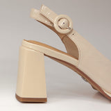 Czółenka Tuffoni lakierowane kremowe na słupku – zbliżenie na pasek z klamrą i elegancki obcas w odcieniu nude