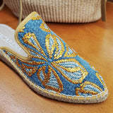 Zbliżenie na haft espadryli Macarena – detal haftu na niebieskiej bawełnianej cholewce z kontrastującymi żółtymi motywami i jutowym obszyciem.