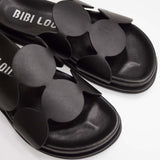 Skórzane klapki hiszpańskiej marki Bibi Lou – czarne, designerskie, ze skóry naturalnej, zbliżenie na stylowe wcięcia geometryczne.