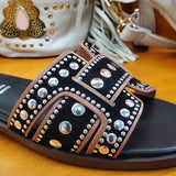 Klapki Bibi Lou – czarne, skórzane, z nitami, zbliżenie na detale – nity w różnych rozmiarach, kontrastowe lamówki i faktura skóry.