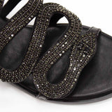 Hiszpańskie klapki Bibi Lou – skórzane, z cyrkoniami i paskami ułożynymi we wzór wijącego się węża, zbliżenie na połyskujące cyrkonie.