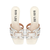 Klapki Bibi Lou widziane z góry – biały model na słupku z szerokim paskiem ozdobionym wycięciami i srebrnymi nitami