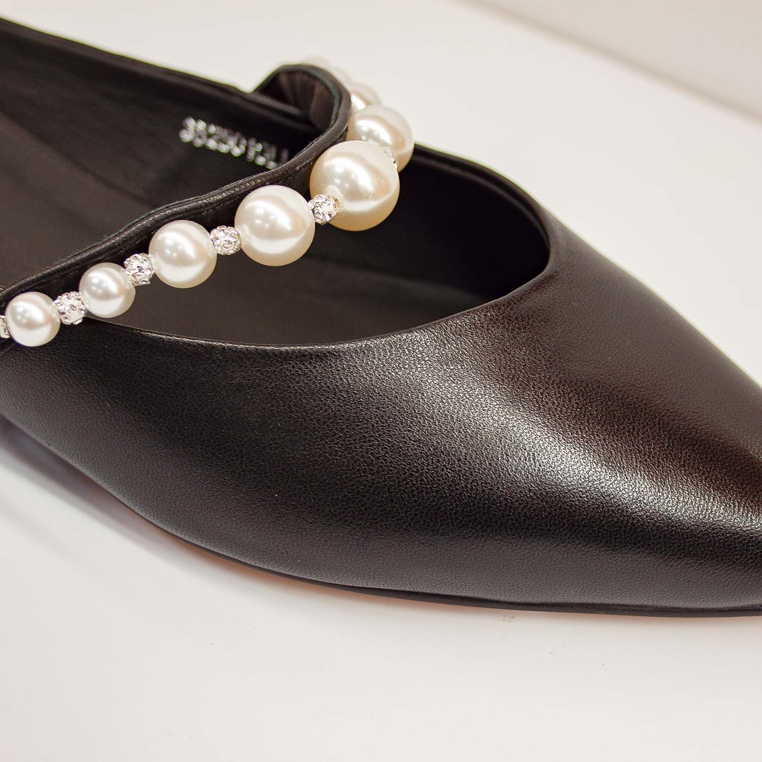 Klapki Tuffoni – czarne, skórzane, z perłami – zbliżenie na nosek i ozdobny pasek z dużych pereł i kryształków
