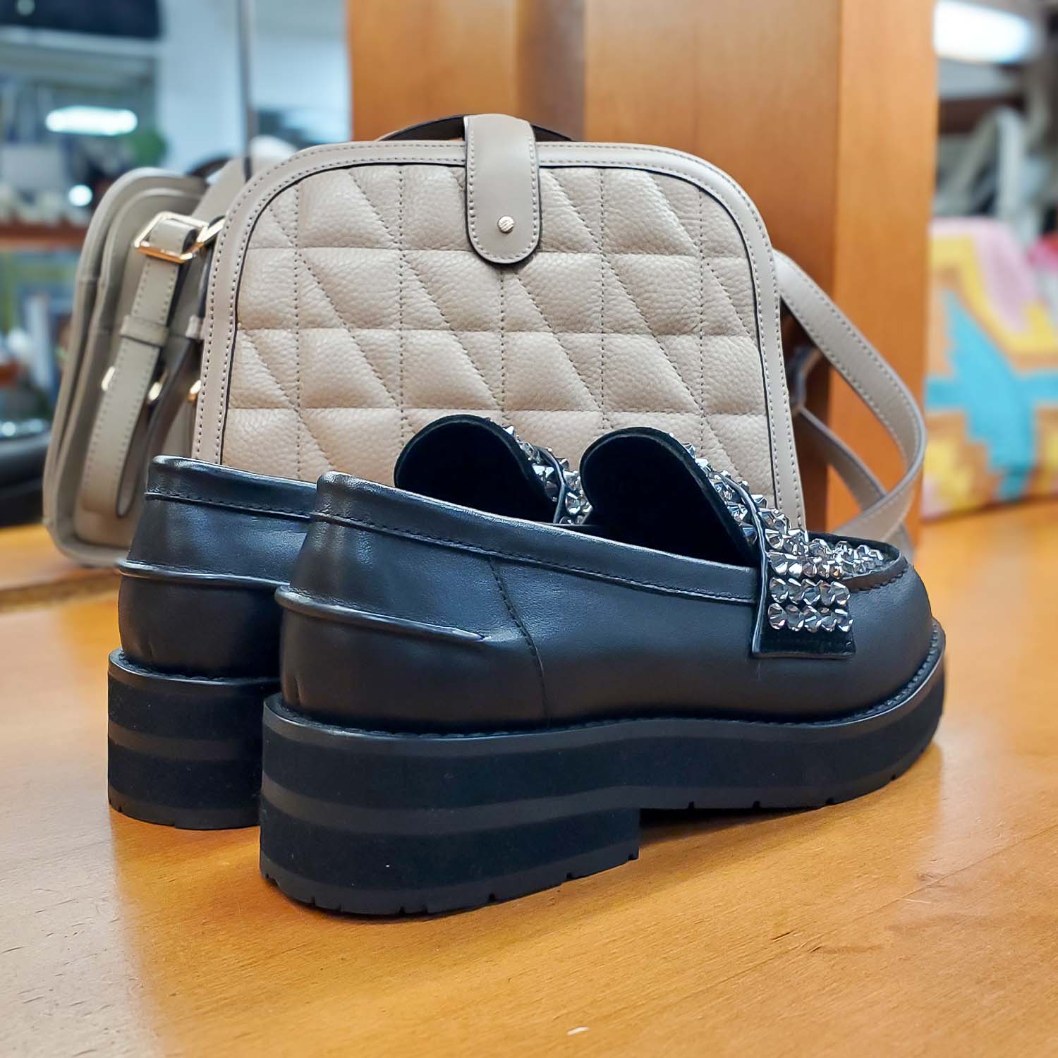 Czarne loafersy Bibi Lou ze skóry naturalnej, widok z tyłu, na tle beżowej torebki