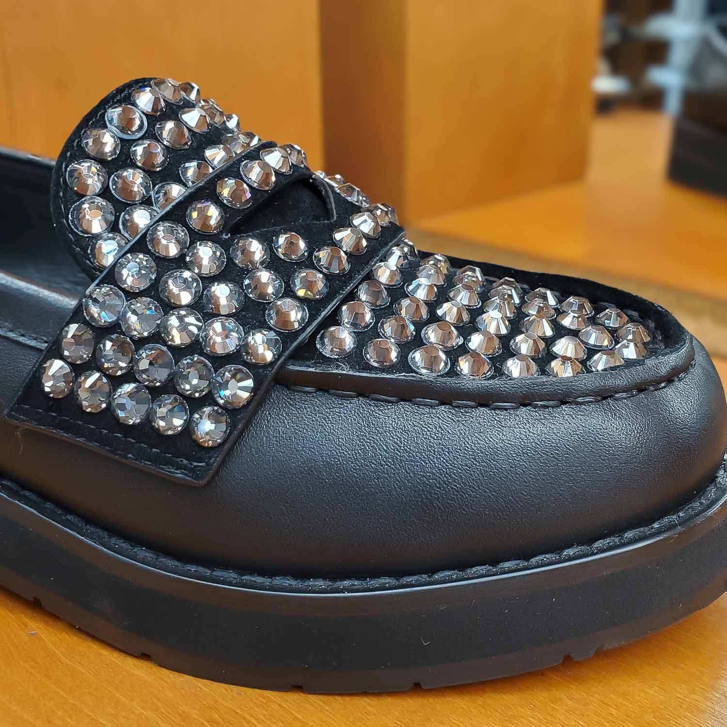 Zbliżenie na cyrkonie zdobiące skórzane loafersy Bibi Lou, detal ozdobnego języka