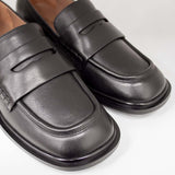 Eleganckie mokasyny Tuffoni – czarne, skórzane, włoskie - zbliżenie na klasyczny pasek na cholewce oraz fakturę skóry.