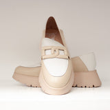 Beżowo-białe mokasyny Wonders z ozdobną klamrą i karbowaną podeszwą – ujęcie frontalne obu butów.