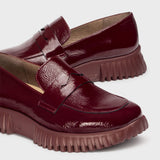 Eleganckie Mokasyny Wonders – bordowe, skórzane, lakierowane, z nowej kolekcji hiszpańskiej marki zbliżenie na fakturę naturalnej skóry.
