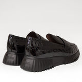 Mokasyny Wonders z nowej kolekcji – czarne, skórzane, lakierowane, widok tyłu eksponujący naturalną skórę zapiętka oraz logo na platformie.