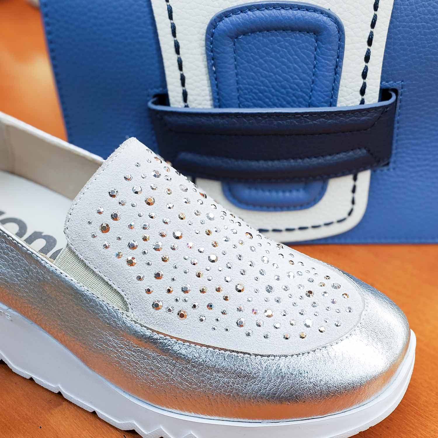 Zbliżenie na cholewkę mokasynów Wonders, ozdobioną połyskującymi cyrkoniami i perforacjami.