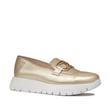 Złote skórzane mokasyny Wonders na białej platformie, widoczne pod lekkim kątem, ozdobna klamra z przodu.