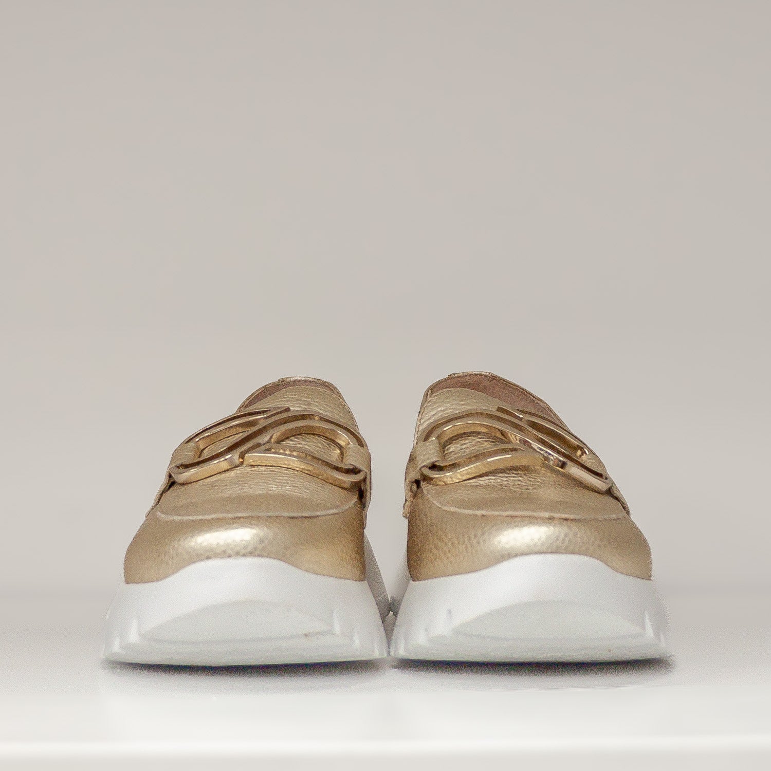 Złote mokasyny Wonders z przodu, z wyeksponowaną metaliczną ozdobą i grubą, białą podeszwą.