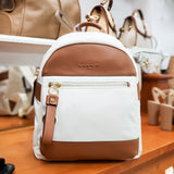 Plecak Nannini na półce sklepowej – kremowo-brązowy plecak w ekspozycji butiku, na tle innych torebek.