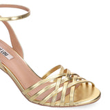 Zbliżenie na przednią część sandałów Bibi Lou Kassia, eksponujące metaliczne, złote paski z miękkiej skóry oplatające stopę.