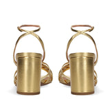 Sandały Bibi Lou złote, skórzane, na obcasie – widok z tyłu – zdjęcie przedstawia tylne ujęcie złotych sandałów Bibi Lou z wysokim słupkowym obcasem i paskiem wokół kostki, wykonanych z naturalnej skóry o metalicznym połysku.