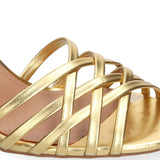 Sandały Bibi Lou złote, skórzane, na obcasie – zbliżenie – zbliżenie na przód sandałów Bibi Lou pokazujące skórzane, cienkie paski oplatające stopę, wykonane z błyszczącej skóry naturalnej w kolorze złotym.