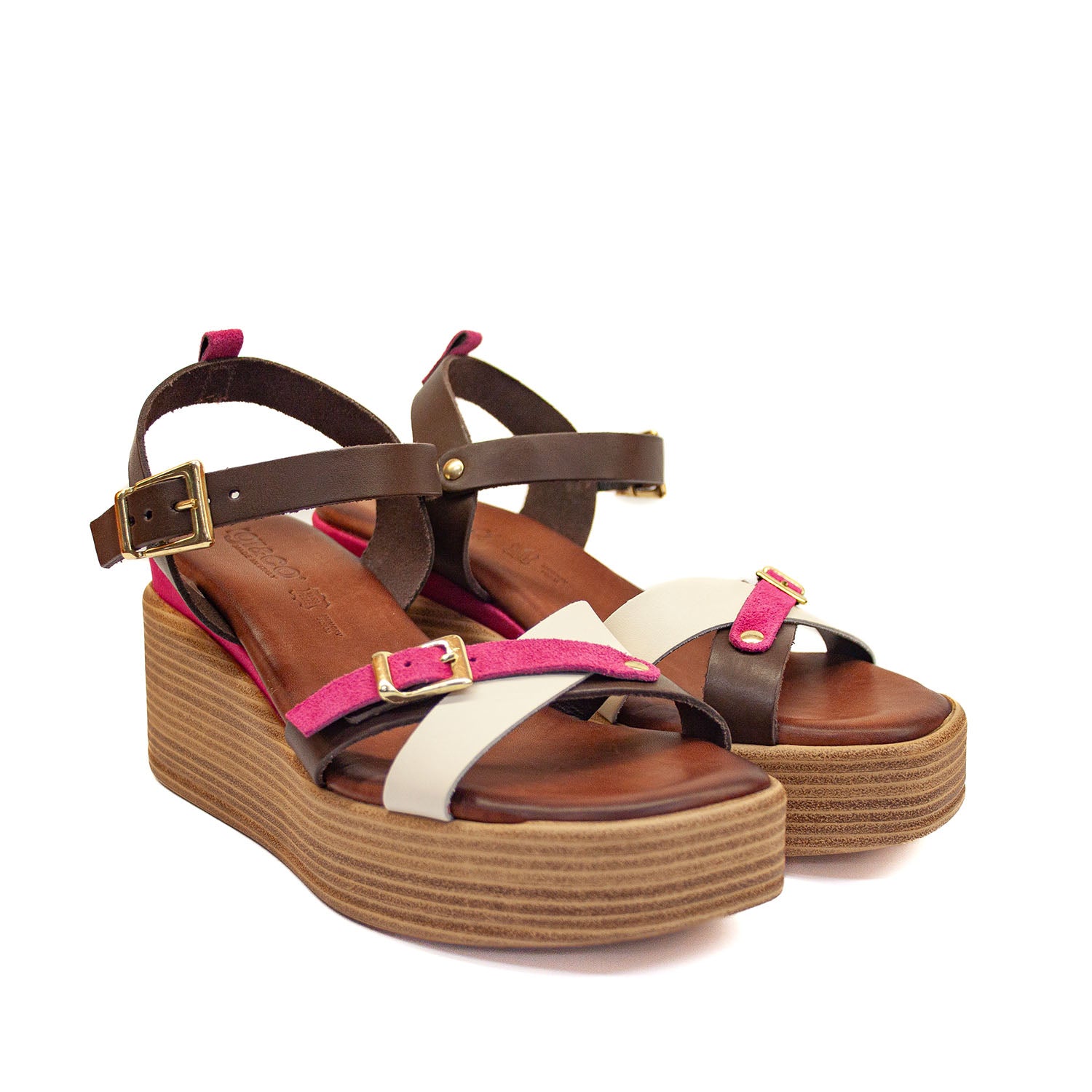Sandały Igi&Co na koturnie widok z profilu – letnie sandały w odcieniach brązu, fuksji i bieli na dekoracyjnej koturnie z efektem słojów drewna, sfotografowane z boku od zewnątrz.