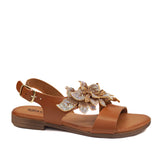 Sandały Igi&Co widok pod kątem – skórzane, brązowe sandały z przestrzenną ozdobą i paskiem zapinanym na złotą klamrę.