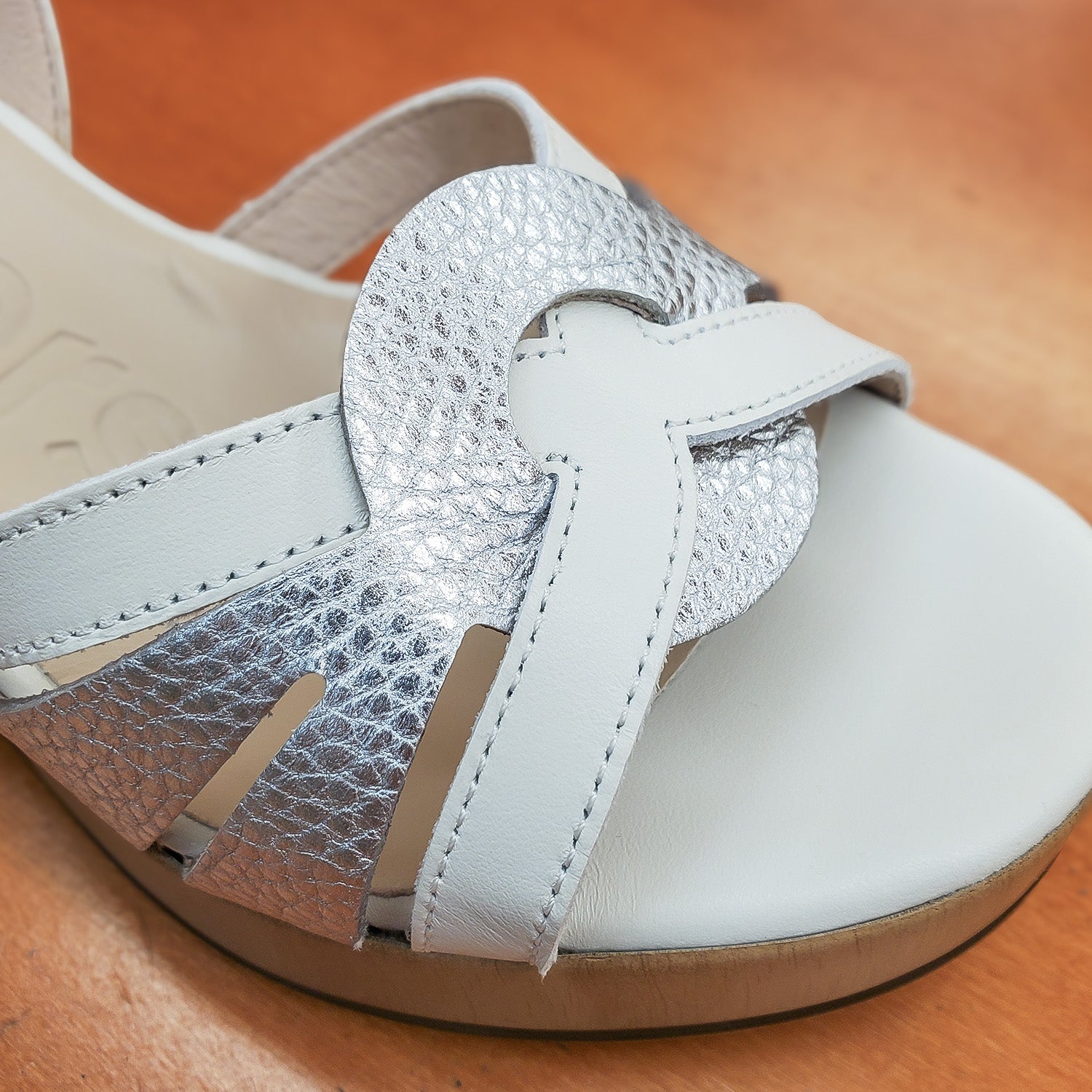 Zbliżenie na przód sandałów Wonders – detale skórzanych pasków, splot i faktura srebrnego elementu kontrastującego z bielą.