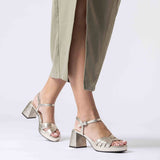 Modelka w beżowej sukience prezentuje złote sandały Wonders z naturalnej skóry, na wysokim słupku i platformie, w ujęciu w ruchu.