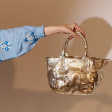 Shopperka Piti Cuiti – złota, skórzana, hiszpańska - widok z modelką trzymającą w ręce torebkę