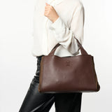 Brązowa shopperka włoskiej marki Plinio Visona – skórzana, włoska,, z naturalnej skóry licowej - widok z modelką w białej koszuli i czarnych spodniach.