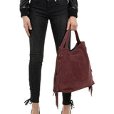 Shopperka Ripani – bordowa, z frędzlami, włoska, ze skóry zamszowej - widok z modelką w czarnych spodniach.
