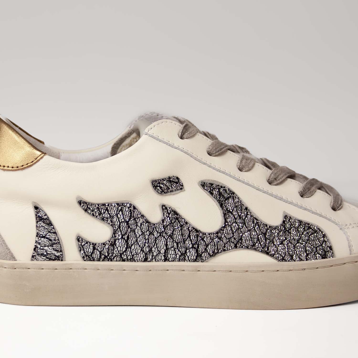 Sneakersy Bibi Lou – skórzane, z motywem płomienia wykonane ze skóry naturalnej licowej i zamszowej - zbliżenie na połyskujący płomień z boku cholewki.