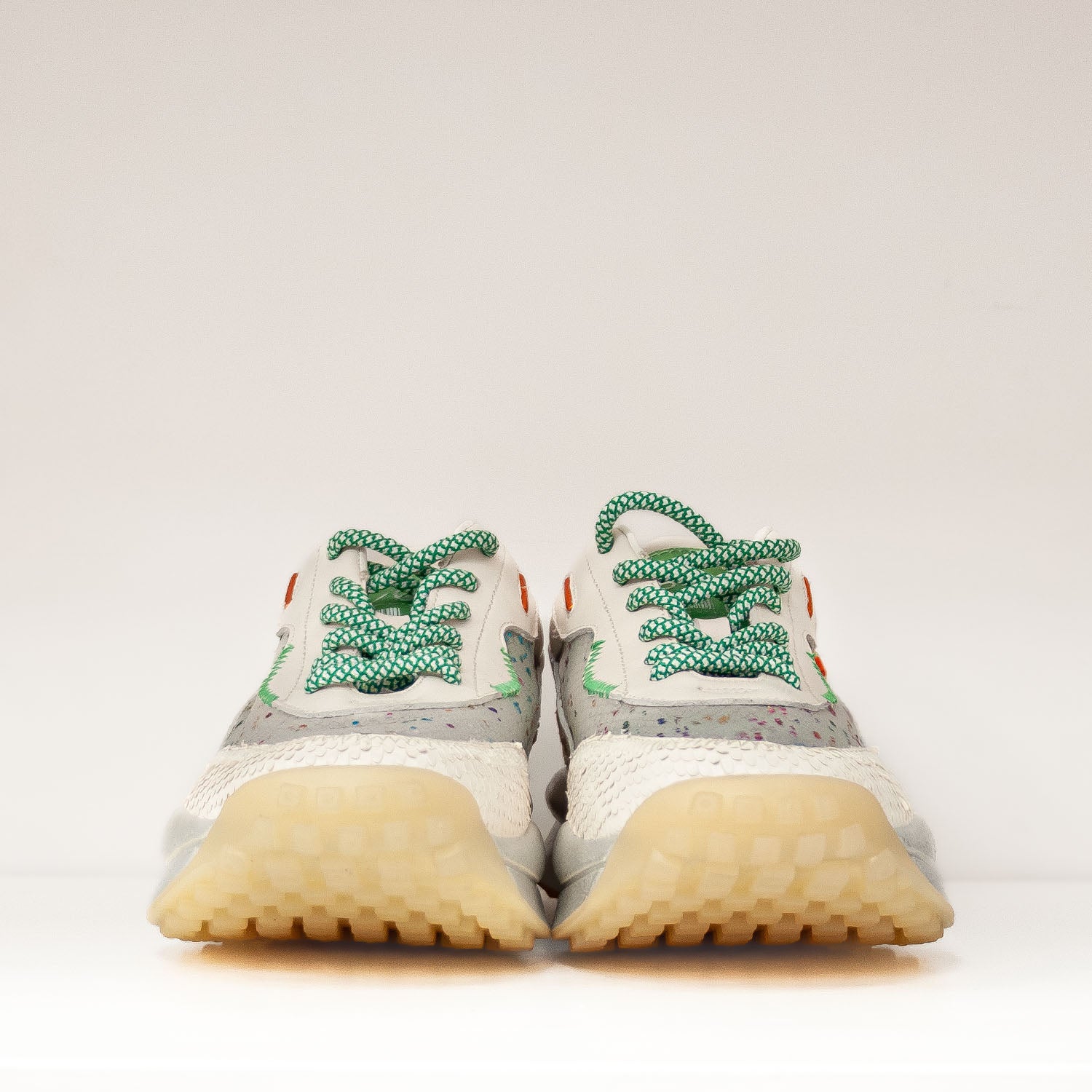 Sneakersy Tuffoni – ecru, z siateczką, skórzane sfotografowane od frontu, zielone sznurówki i kolorowe drobinki na prześwitującej siateczce.