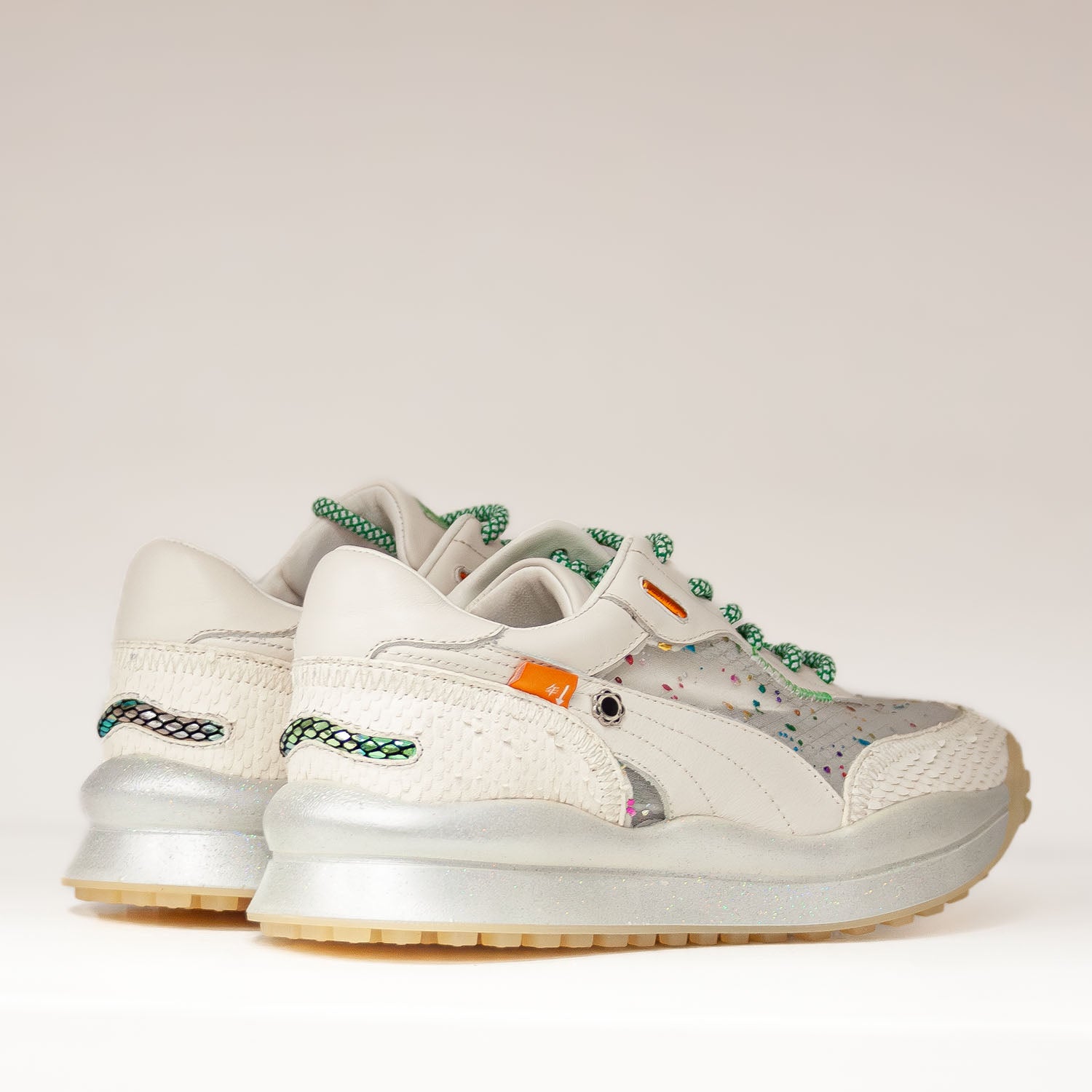 Sneakersy Tuffoni – ecru, z siateczką, skórzane pokazane z tyłu, z widoczną fakturą pięty, metaliczną podeszwą i pomarańczowymi detalami.