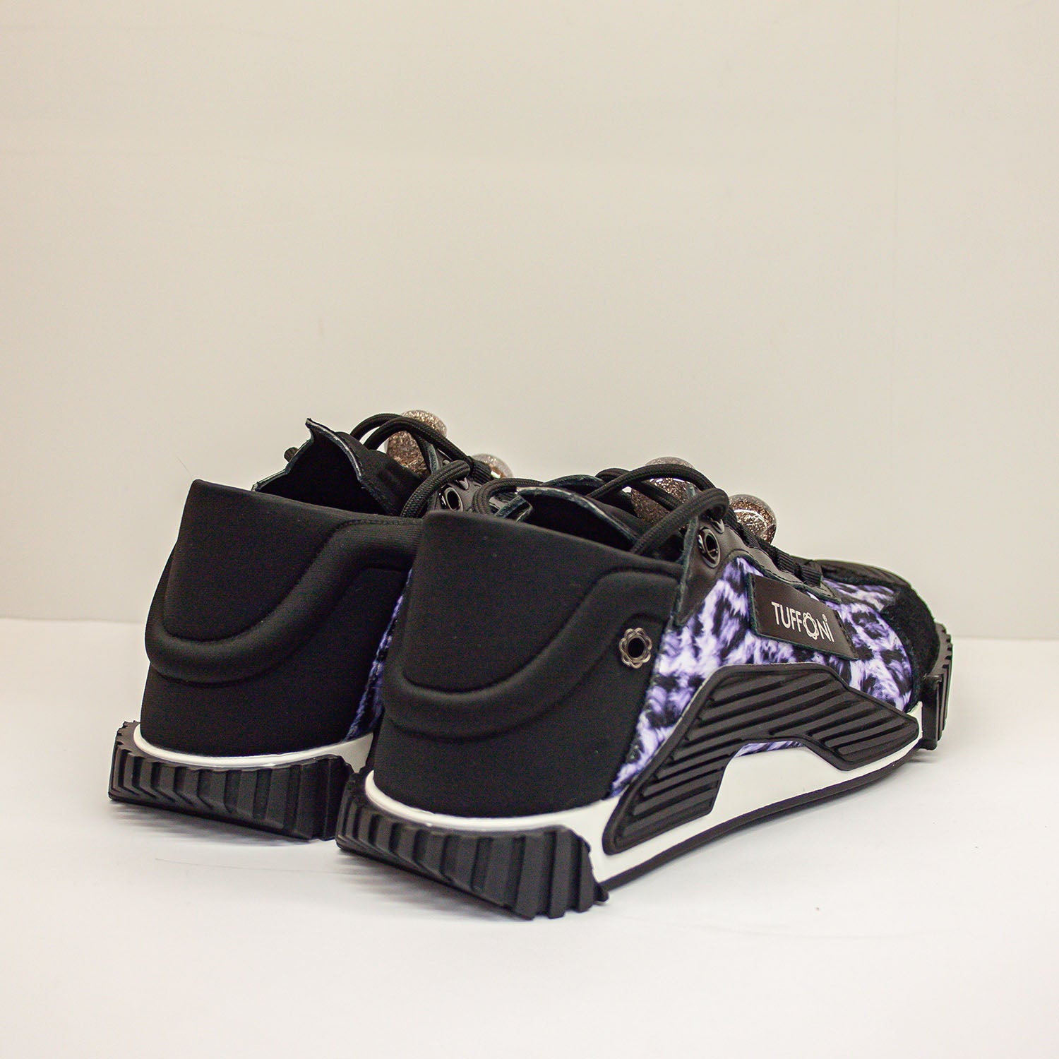 Sneakersy Tuffoni od strony pięty, z dobrze widoczną grubą podeszwą i zamszową cholewką w zwierzęcy deseń.