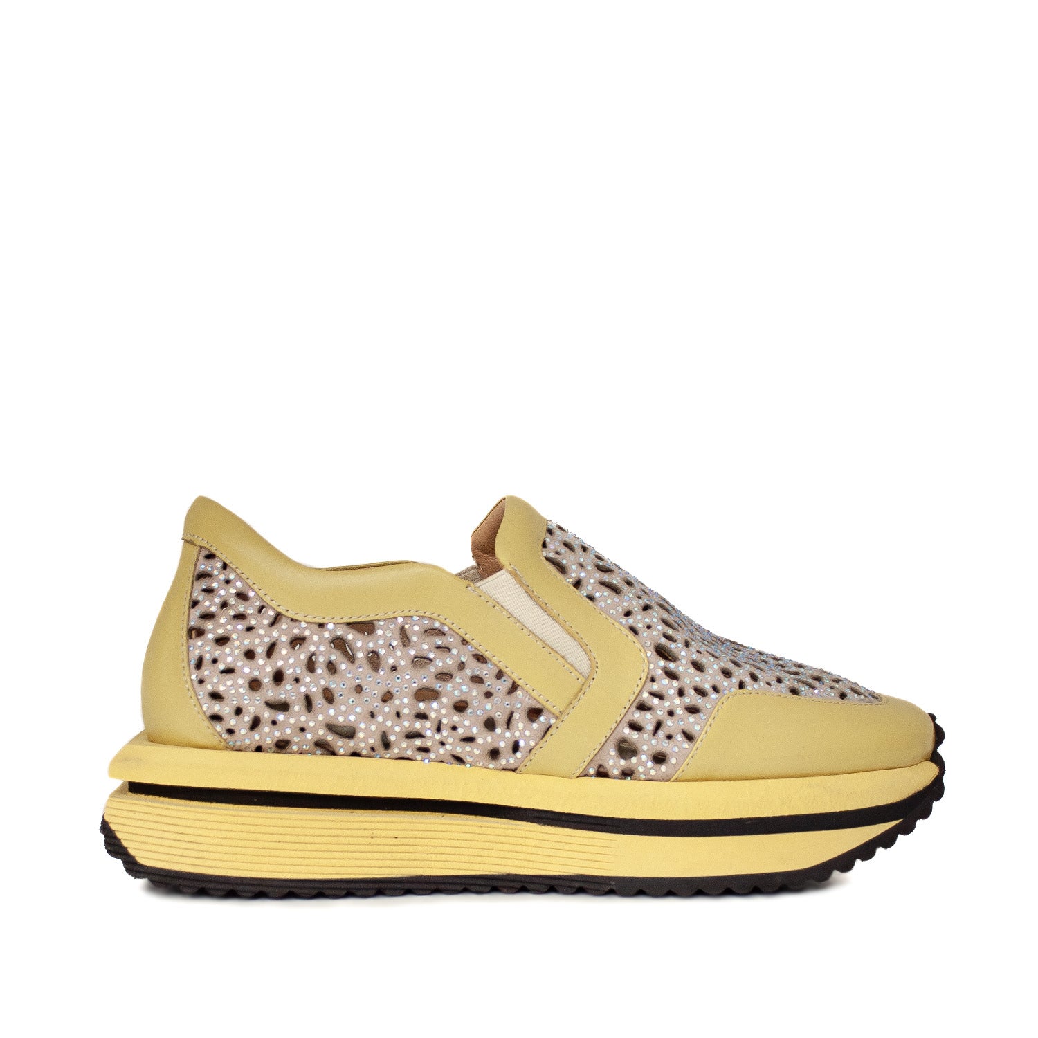 Zbliżenie na sneakersy Tuffoni – żółte, ażurowe, skórzane z wycięciami w cielęcej skórze i żółtą platformą, ujęcie z boku.