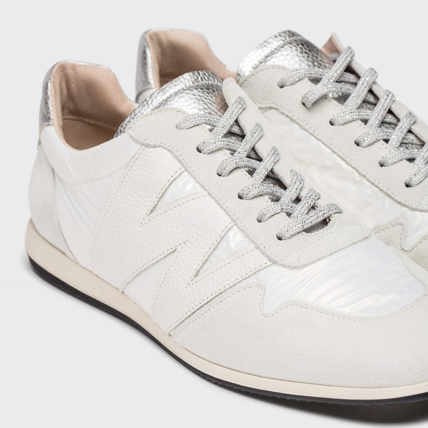 Sneakersy Wonders białe skórzane niskie – zbliżenie na detale cholewki, srebrne sznurówki i strukturę skóry.