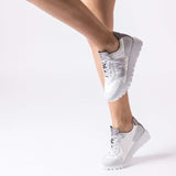 Sneakersy Wonders – srebrne, białe, sportowe, ujęcie na modelce – stylizacja z krótkimi spodenkami, podkreślająca lekkość i nowoczesny design.