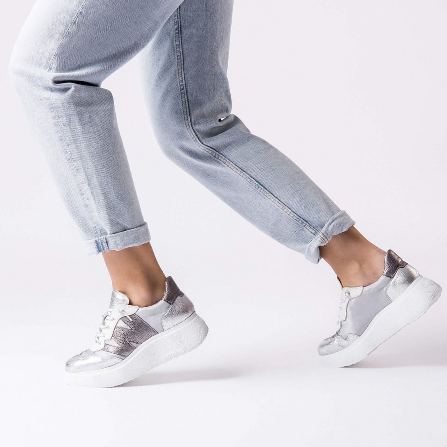 Sneakersy Wonders srebrne skórzane na platformie – stylizacja na modelce w ruchu, podkreślająca sportowo-miejski look.