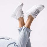 Sneakersy Wonders – srebrne, skórzane, sportowe, ujęcie na modelce – stylizacja z jasnymi spodniami, podkreślająca sportowy charakter butów.