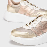 Sneakersy Wonders – złote, skórzane, na platformie w dużym zbliżeniu, z widocznym logo „W” i eleganckim, tłoczonym wzorem skóry.