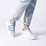 Sneakersy Wonders w bieli i błękicie na modelce – sportowy, lekki fason zestawiony z jasnymi jeansami