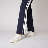 Białe sneakersy Tosca Blu w stylizacji, noszone z granatowymi spodniami z lampasami.
