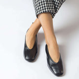 Czarne baleriny Wonders PEPA w stylizacji z eleganckimi spodniami w kratę.