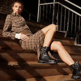 Czarne botki Wonders w stylizacji – modelka w sukience na schodach.