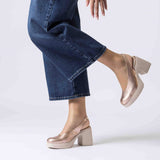 Czółenka Wonders NAIMA na słupku w kolorze złota, ujęcie na modelce – buty w stylizacji z jeansami, widoczny elastyczny pasek i stabilny obcas.