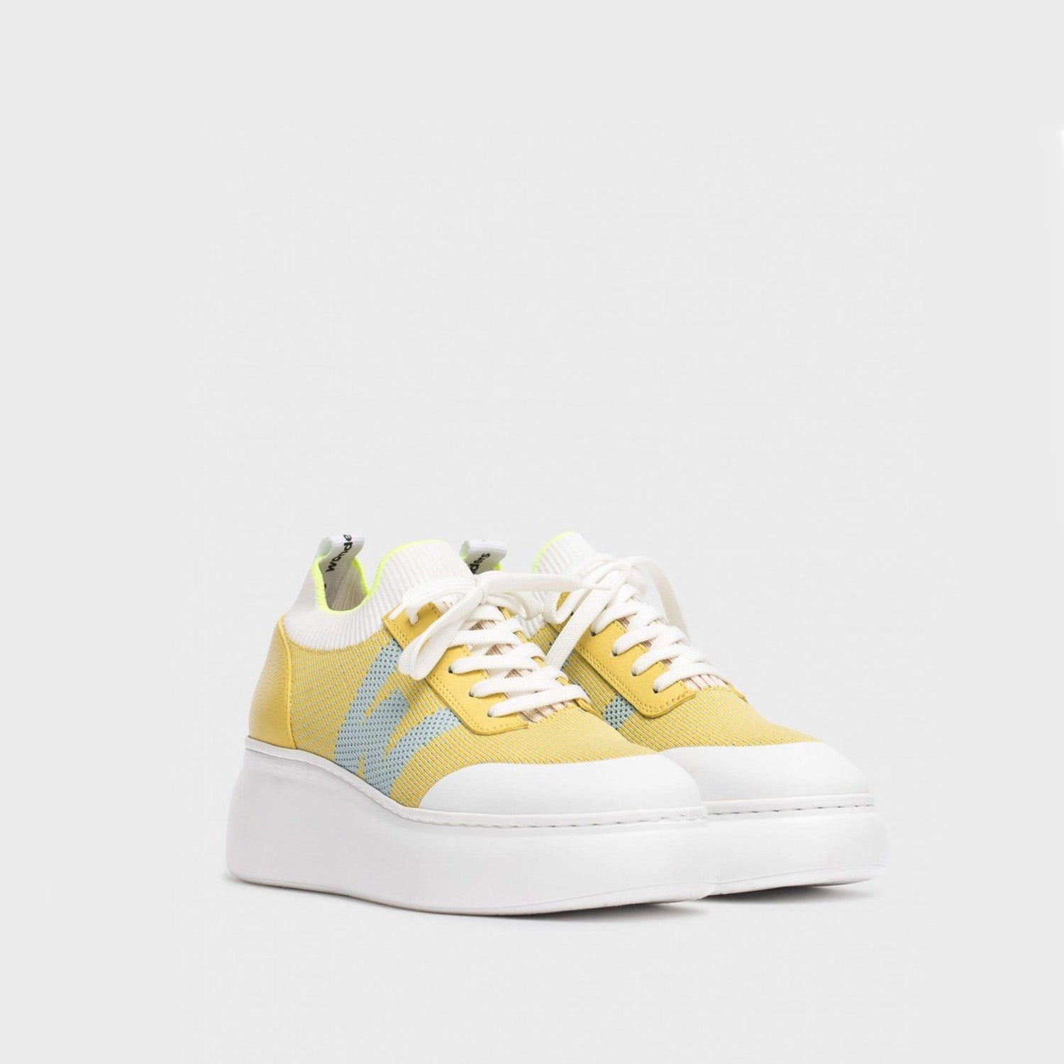 Żółte sneakersy Wonders z białą platformową podeszwą, widok z profilu.