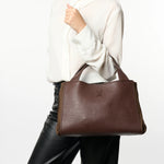 Brązowa shopperka włoskiej marki Plinio Visona – skórzana, włoska,, z naturalnej skóry licowej - widok z modelką w białej koszuli i czarnych spodniach.