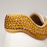 Hiszpańskie sneakersy Alma En Pena – białe, skórzane, z cyrkoniami - zbliżenie na musztardowe cyrkonie.