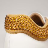 Hiszpańskie sneakersy Alma En Pena – białe, skórzane, z cyrkoniami - zbliżenie na musztardowe cyrkonie.